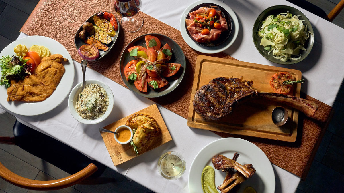 Argentine asado spread at Graziano's: tomahawk steak, empanadas, provoleta and sides