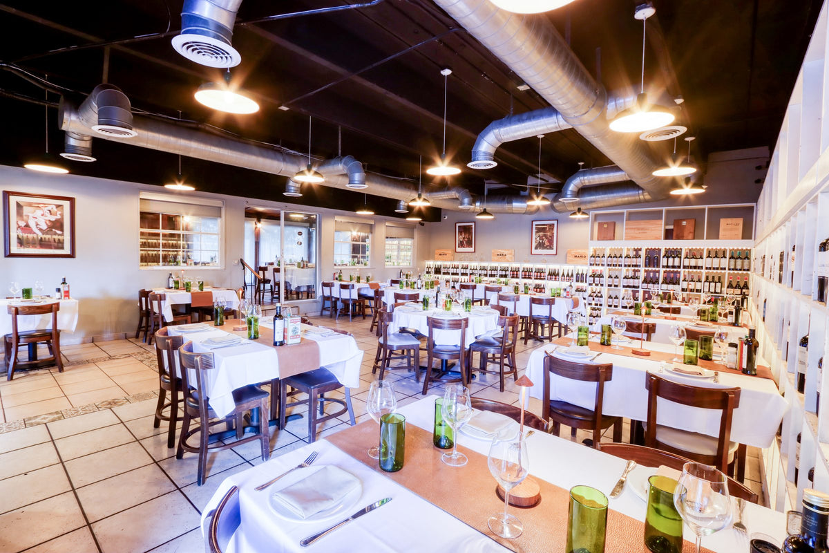 Dining room at Graziano's Restaurant Hialeah with the wine wall and set tables