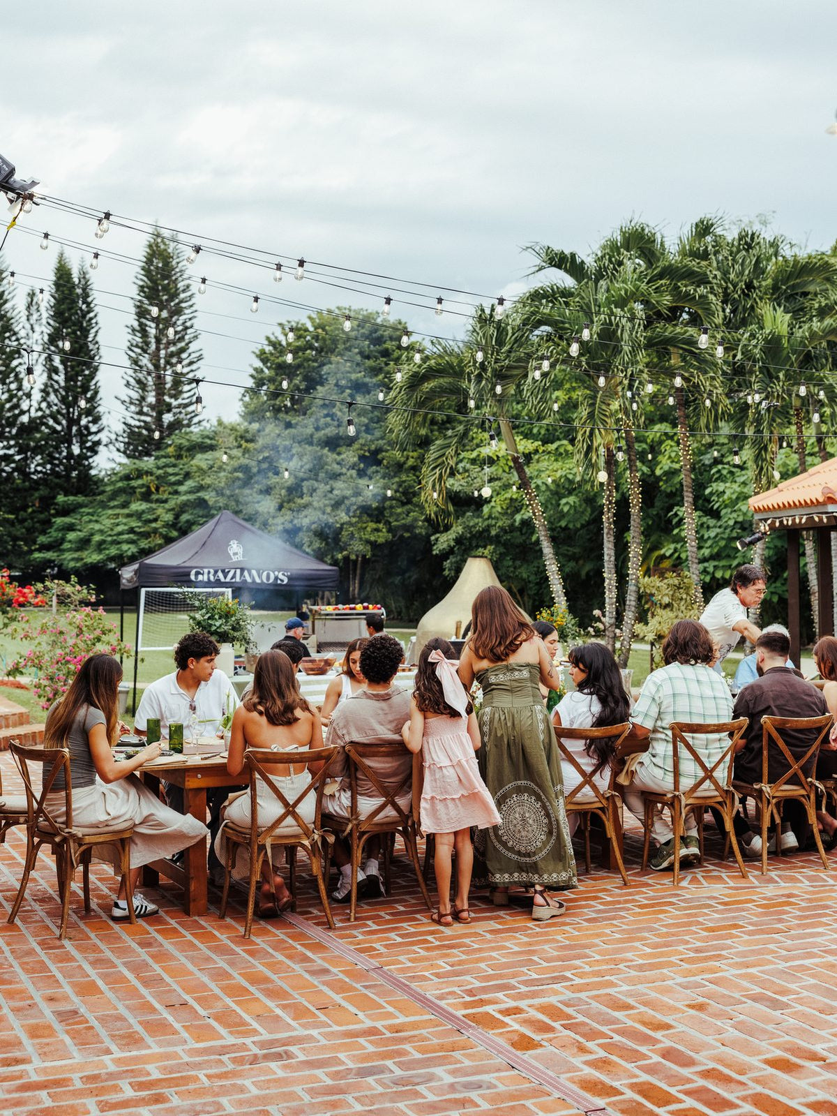 Outdoor asado catering event with long tables under the trees