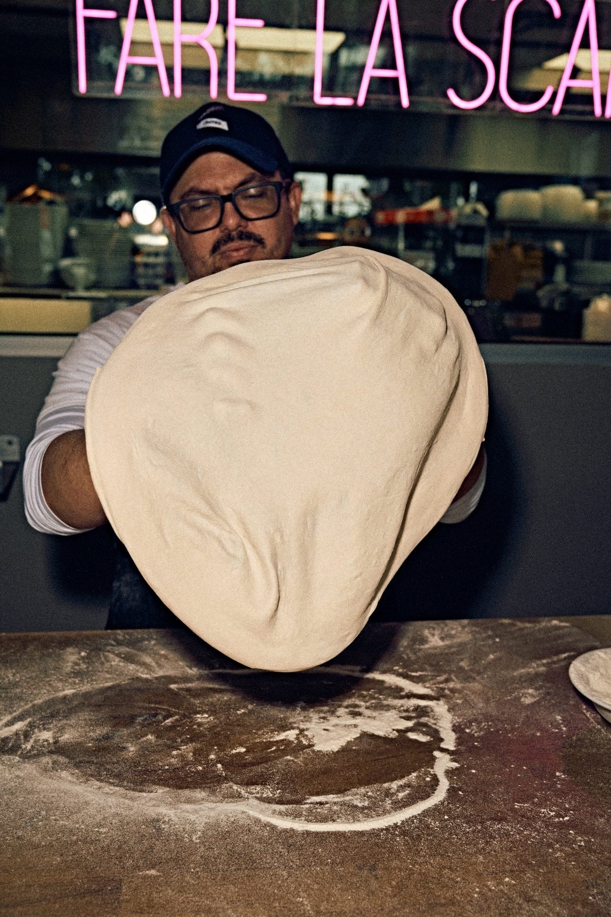 Pizzaiolo stretching dough at Lucia Pizzeria