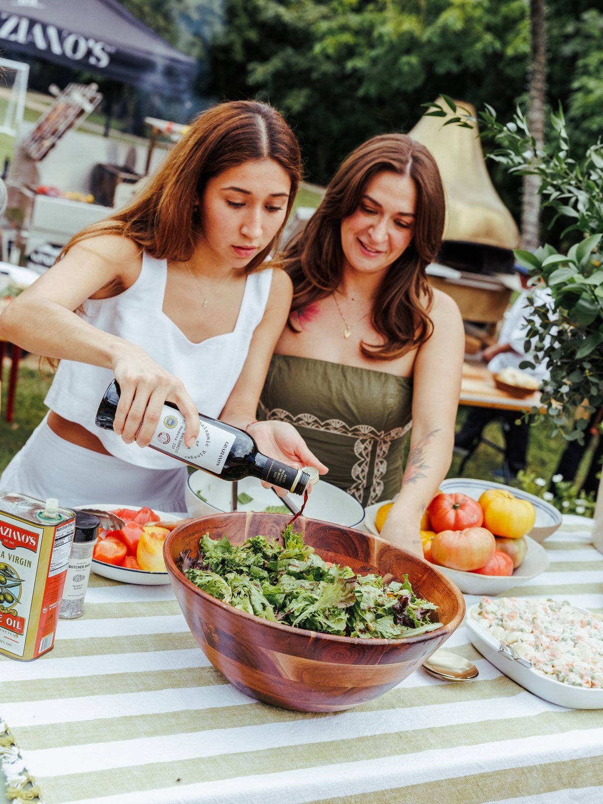 Preparing salad and wine at an asado at home