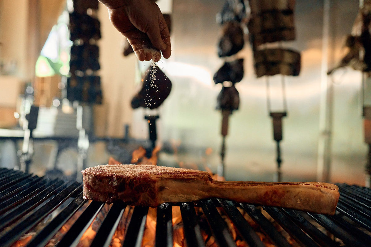 Tomahawk on the grill with skewers behind at Graziano's